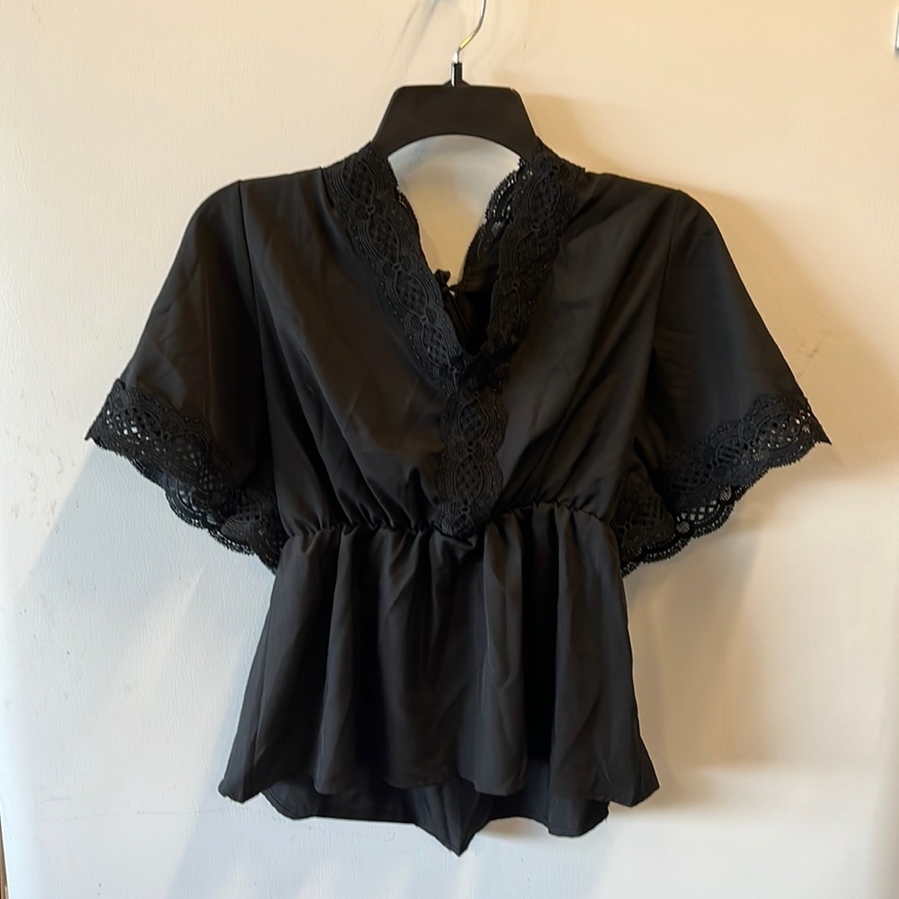 Black top with lace sleeves and neckline. Women’s size medium